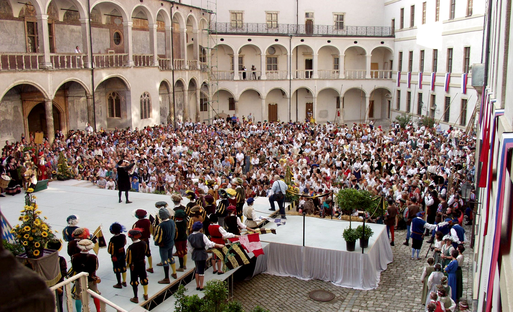 Many people in medieval dress in the castle courtyard
